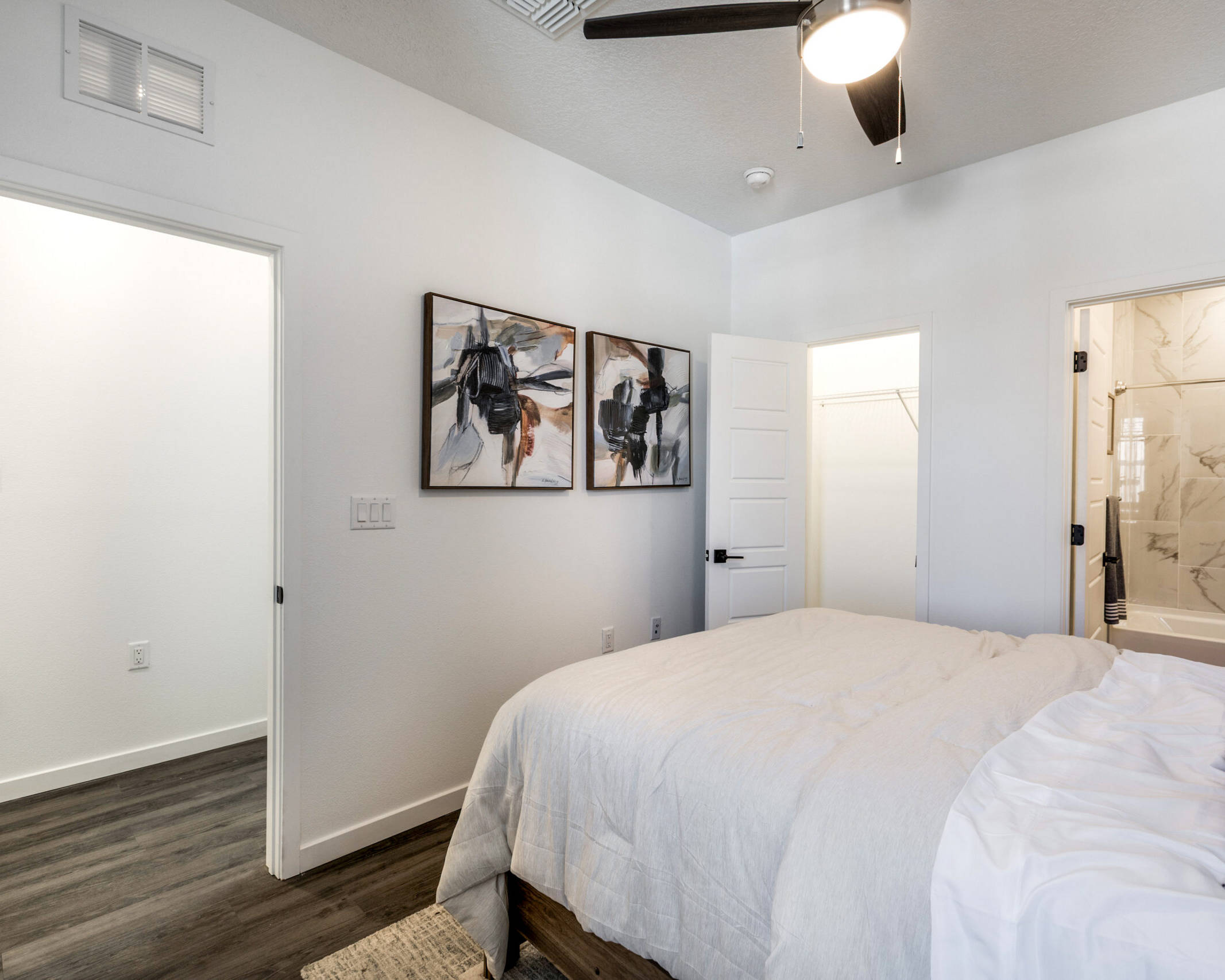 clean bedroom with a full bath and ceiling fan.